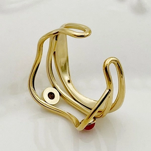 Detailed macro view of gold-plated hollow chain ring featuring a red circular gemstone