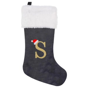 Close-up of grey velvet Christmas stocking with white faux fur and golden glitter letter S