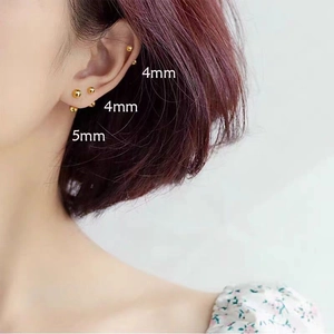 Model wearing 4mm and 5mm gold ball stud earrings made of durable stainless steel