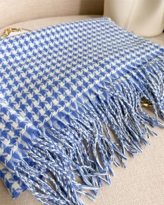 Detail of blue and white houndstooth cashmere scarf with soft fringe texture