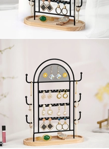 Detail of jewelry organizer with black metal mesh hooks and light wood base tray