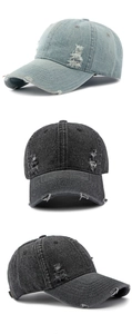 Detail showing distressed holes and frayed edges on washed denim baseball cap