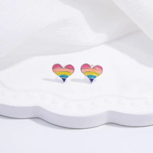 Macro view of silver heart earrings with colorful rainbow striped enamel dripping oil finish