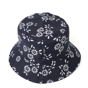 Close-up of small white daisy pattern on cotton reversible bucket hat with neat stitching