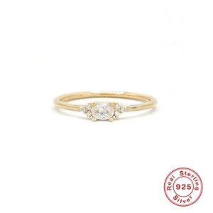 Detail of 925 sterling silver gold ring with oval zircon and side stones for women