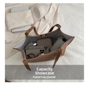Top view of large brown leather tote bag interior showing phone, wallet and sunglasses