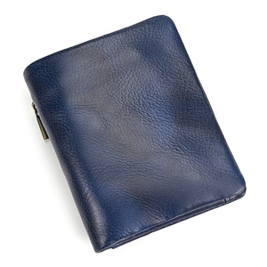 Detailed macro view of deep blue litchi grain genuine leather texture on bifold wallet