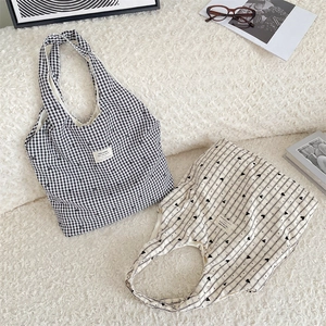 Flat lay of plaid and heart pattern canvas tote bags on soft textured background