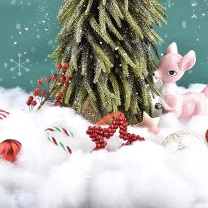 Artificial snow scene with mini Christmas tree, pink deer, and festive holiday decorations