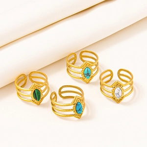 Detail of four gold adjustable stainless steel rings with colorful oval gemstones