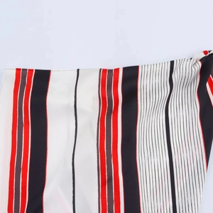 Close-up of the asymmetric striped fabric showing red, black, and white weave details