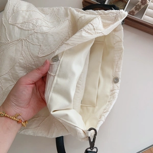 Detail of leaf embroidery on canvas tote with magnetic clasp and inner pocket