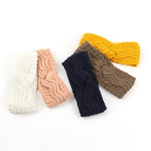 Flat lay of five knitted fleece-lined headbands in various colors with twist-knot detail