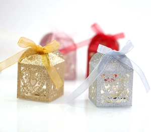Détail de boîtes cadeaux pailletées en forme de cœur avec rubans en or et argent