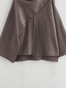 Detail view of the brown knitted coat's asymmetric hem and premium wool texture