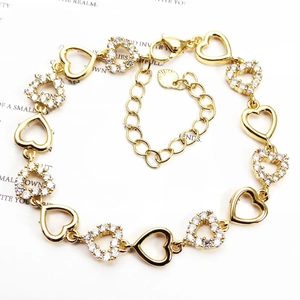 Detail of adjustable gold heart bracelet with micro-pave white zircon floral accents