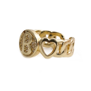 Detail of a golden chain-link ring featuring a heart motif and the letter B charm