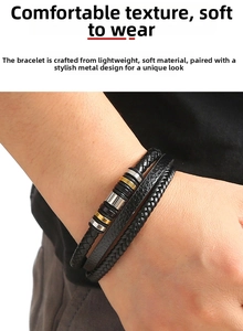 Nahaufnahme des mehrlagig geflochtenen Lederarmbands mit Gold- und Silberringen