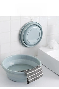 Space-saving light blue folding basin shown in wall-hung and expanded water-use modes