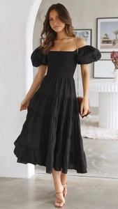 Detail view of black off-shoulder puff sleeves and tiered skirt on summer dress