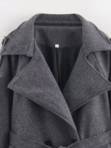 Close-up of deep gray wool coat featuring lapel collar, buttons and fabric texture