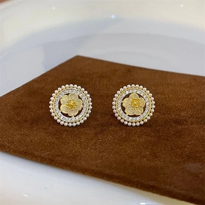 Macro detail of vintage floral earrings with micro pearls and sparkling zircon accents