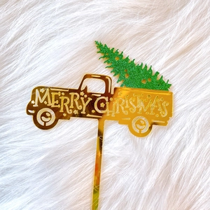 Detail of Christmas cake topper featuring golden mirror acrylic truck with green glitter tree
