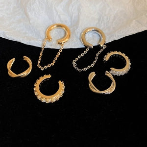 Detailed close-up of zircon-encrusted ear cuff set in gold and silver finishes