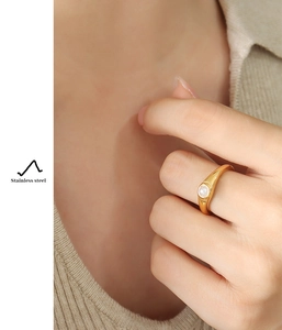 Detailansicht eines 18K vergoldeten Edelstahlrings mit weißer Perle am Finger