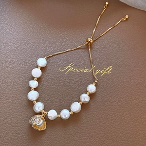 Detail van parelschelp hanger armband met verstelbare gouden ketting en sprankelende kristallen
