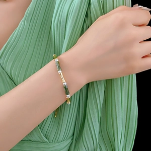 Detail showing gold bamboo accents, green stones, and pearls on this elegant bracelet