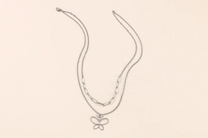 Detail of silver layered necklace featuring paperclip chain and hollow butterfly pendant