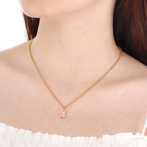 Gros plan d'un collier chaîne dorée avec pendentif ours rose sur le cou d'un mannequin