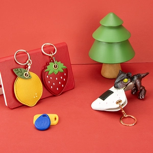 Cartoon fruit and rice ball leather AirTag case with gold keychain in a gift setup