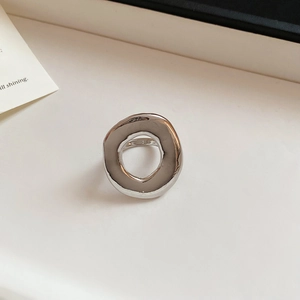 Macro shot of silver irregular cutout ring with polished mirror finish and organic fluid shape