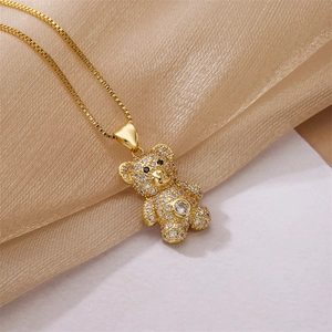 Close-up of gold bear pendant with pavé cubic zirconia on silk fabric background