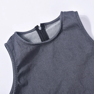 Detailed view of the dark grey denim jumpsuit neckline and metal zipper closure