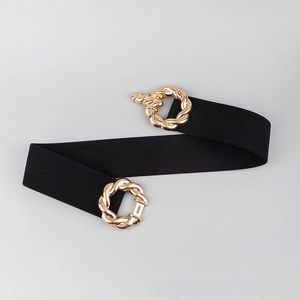 Detail of a wide elastic black waist belt with vintage-style twisted gold metal rings