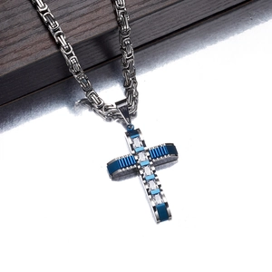 Makroaufnahme von blau-schwarzem Kreuzanhänger mit weißem Zirkon und Zopfkette