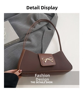 Detailed view of the dark brown baguette bag with a golden metal bow buckle