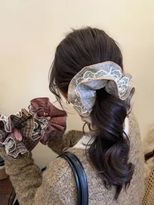Detail of vintage lace scrunchies in red and blue plaid fabric for women hair styling