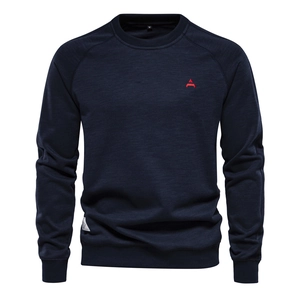 Detail of dark blue sweatshirt with raglan sleeves and red embroidered logo on chest