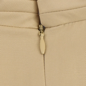 Macro shot of invisible zipper detail on khaki fabric for an elegant long dress