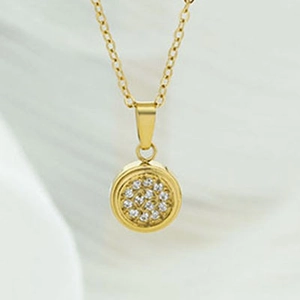 Detail shot of a minimalist gold necklace with a micro-set zircon round pendant