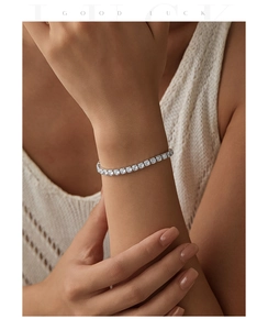 Close-up of a silver S925 sterling silver tennis bracelet with square-cut sparkling crystals