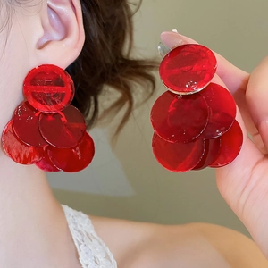 Detailed view of red layered shell tassel earrings with a glossy acrylic finish