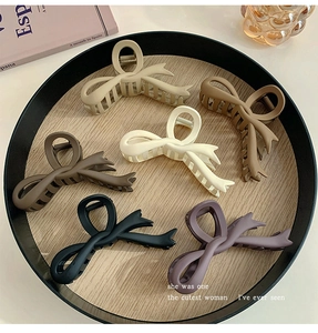 Detailed macro view of large matte butterfly bow hair claws in six Morandi color variations