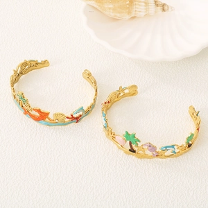 Detailed close-up of golden ocean-themed bracelets with colorful enamel sea life charms
