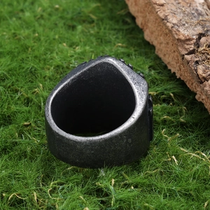 Vintage punk stainless steel cross ring for men with distressed silver finish on grass