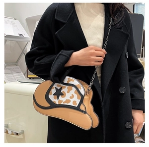 Brown cowboy hat shaped crossbody bag with cow print detail and star accent